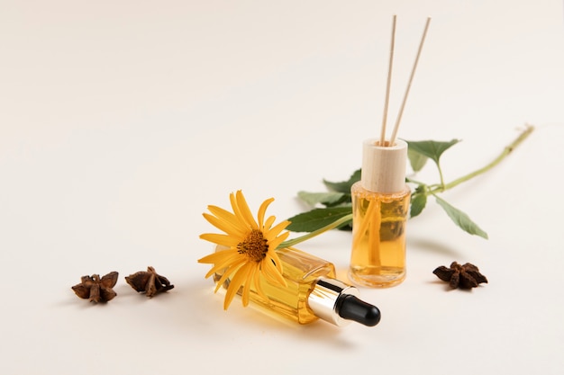 essential oils and flower on plain background 