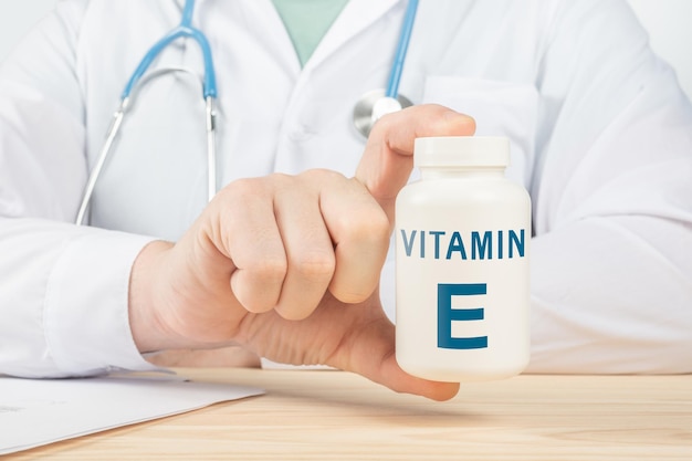 Foto essentiële vitamine e en mineralen voor de mens. arts raadt aan vitamine e in te nemen. arts praat over de voordelen van vitamine e. e vitamine - gezondheidsconcept