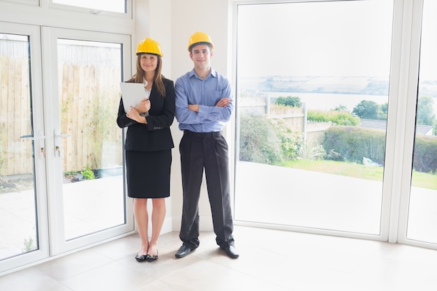 Estate agent and client wearing hardhats
