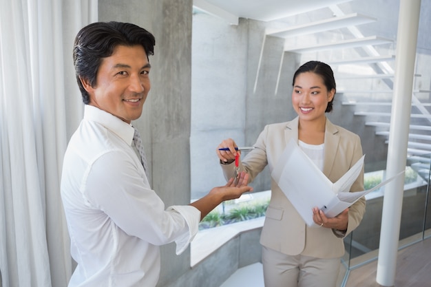 Estate agent giving house key to buyer