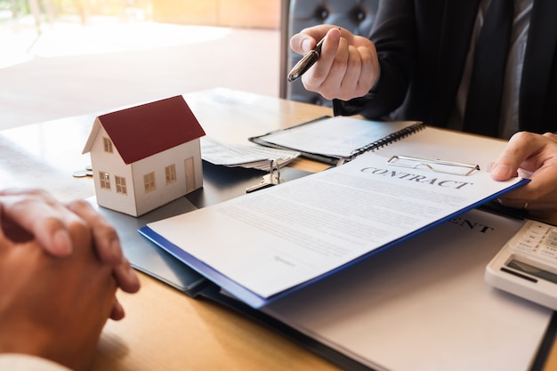 Estate agent giving house keys customer sign agreement property for sale