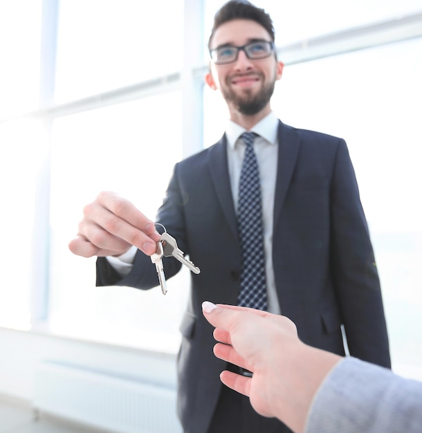 Агент по недвижимости дает ключи от дома человеку