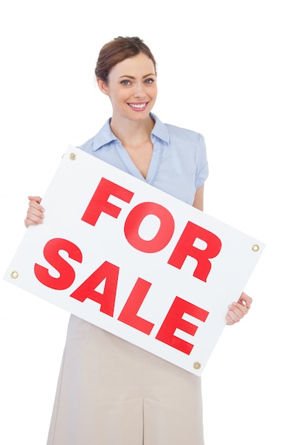 Estate agent posing with for sale sign