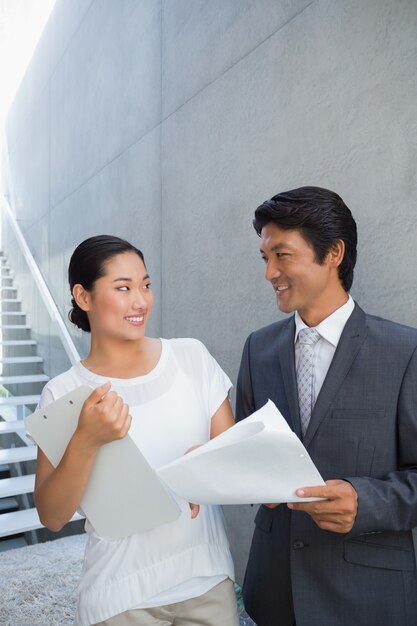 Estate agent showing lease to customer and smiling