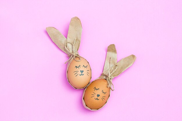 Ester eggs painted like a bunny on a pink desk