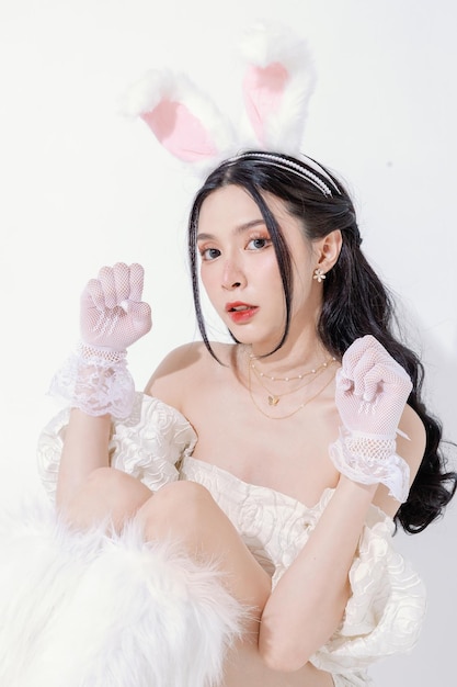 Ester festival concept Leuke Aziatische vrouw heeft een mooi gezicht voelt zich gelukkig, heeft een perfect heldere huid en slank lichaam met pluizige konijnenoren op geïsoleerde witte achtergrond