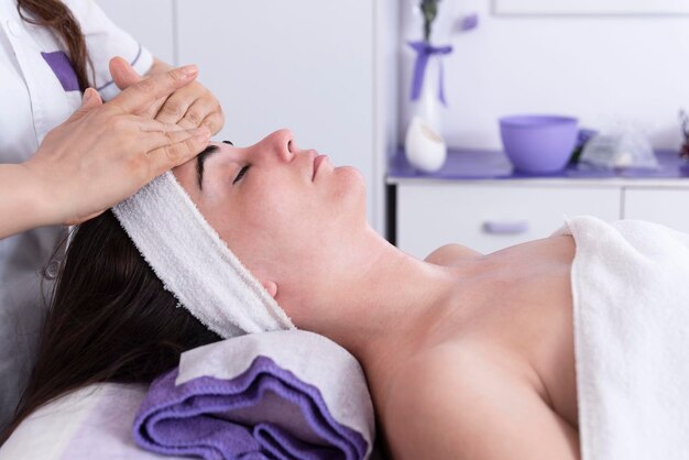 Esthetician performing professional facial massage on woman39s face in spa clinic Antiaging massage with face lift Professional lymphatic drainage massage in the beauty salon