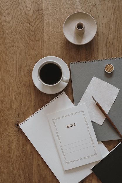 Esthetisch minimalistisch concept Papieren blad notebook kopje koffie album briefpapier op houten tafel achtergrond Plat lag bovenaanzicht