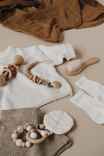 Esthetisch Scandinavisch pasgeboren babykleding, verzorgingsaccessoires, speelgoed op neutrale pastelbeige kleurachtergrond Trendy elegante luxe babyset