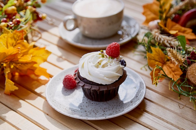 Esthetische franse gluten- en suikervrije cupcake close-up tussen herfst sfeervolle decoratie en kopje koffie Gezellig ontbijt