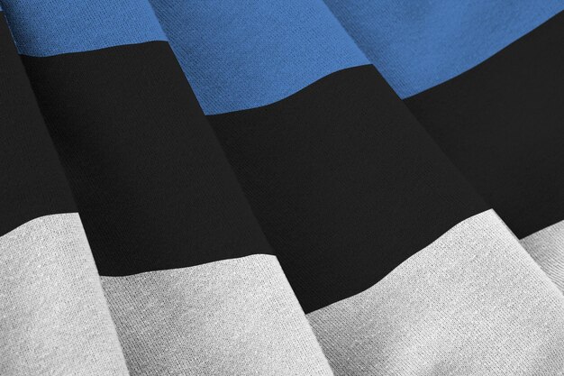 Estonia flag with big folds waving close up under the studio light indoors The official symbols and colors in banner