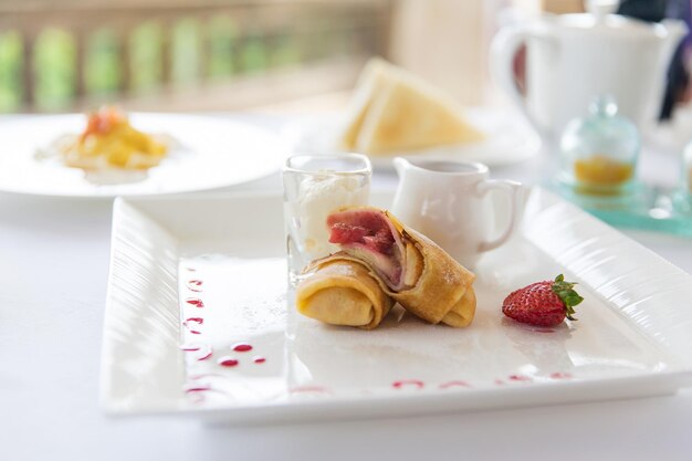 eten, dessert, ochtend en eetconcept - close-up van bord met pannenkoeken en honing of jam op tafel