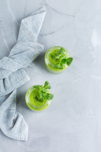 Eten en drinken, gezond dieet en voeding, levensstijl, veganistisch, alkalisch, vegetarisch concept. Groene smoothie met biologische ingrediënten, groenten op een moderne keukentafel. Ruimte achtergrond kopiëren