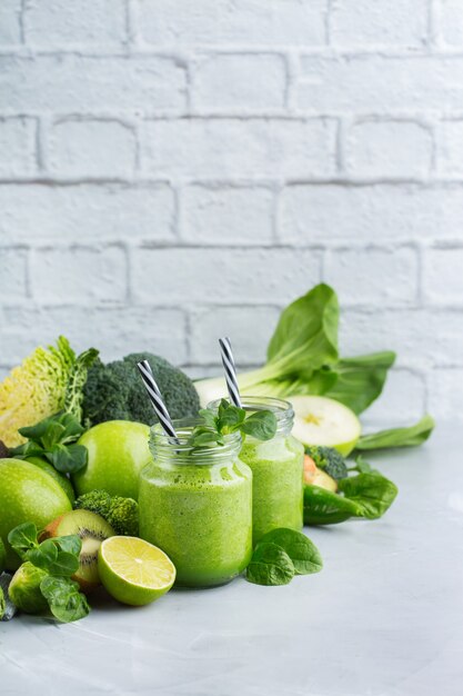 Eten en drinken, gezond dieet en voeding, levensstijl, veganistisch, alkalisch, vegetarisch concept. groene smoothie met biologische ingrediënten, groenten op een moderne keukentafel. ruimte achtergrond kopiëren