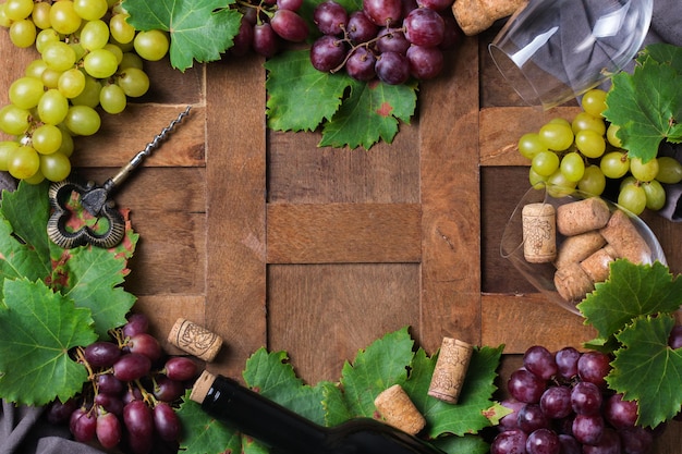 Eten en drinken oogst herfst val concept wijnproeverij degustatie uitnodigingskaart met symbolen wijnstok fles glazen kurkentrekker houten achtergrond