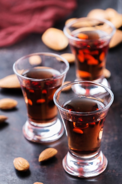 Eten en drinken partij alcohol concept Traditionele Italiaanse zoete amandel likeur amaretto op een grunge zwarte tafel digestief drank