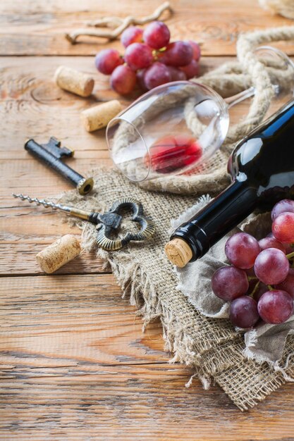 Foto eten en drinken stillevenvakanties seizoensgebonden oogsten herfstconcept fles kurkentrekker kurken glas rode wijn en druiven op een rustieke houten tafel