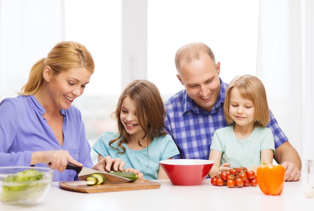 Foto eten, gezin, kinderen, geluk en mensenconcept - gelukkig gezin met twee kinderen die thuis eten