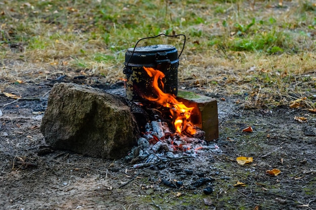 Eten koken in een waterkoker op een vreugdevuur in het bos