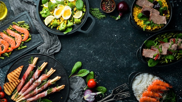 Eten Set gerechten op zwarte tafel Vlees- en visgerechten Rustieke stijl