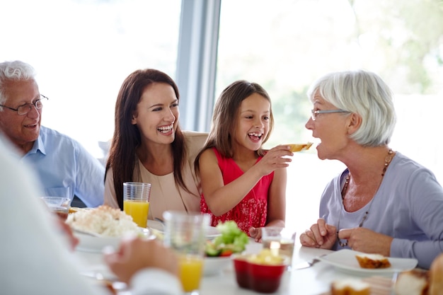 Eten smaakt beter als je het met familie eet Shot van een gelukkige familie die meerdere generaties samen aan het eten is