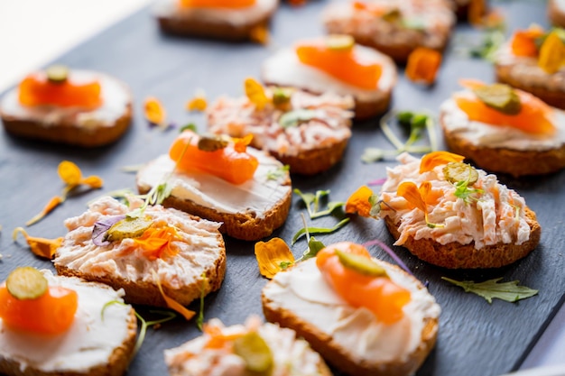 Eten van een doorstoken zalmevenement Bruiloftslunch en -buffet Feest of feestdiner en eten op een zwart bord