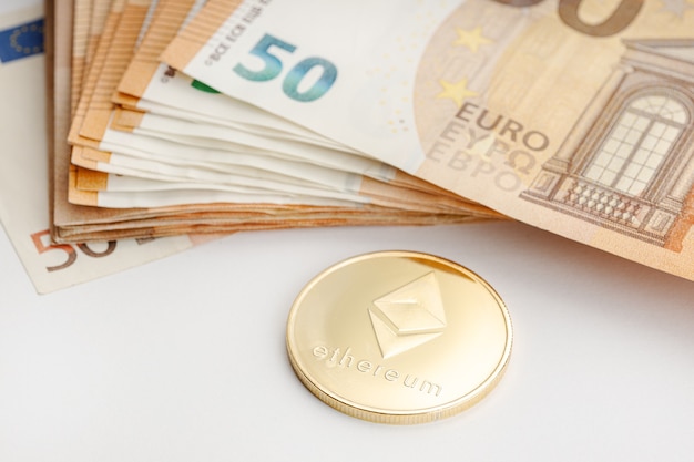 Ethereum coin and Euro banknotes. Blockchain money versus fiat money concept