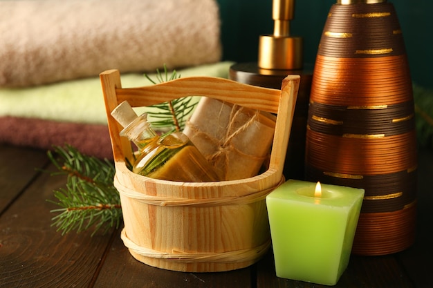 Etherische olie van dennen handgemaakte zeep in houten emmer en spa-behandelingen op houten achtergrond