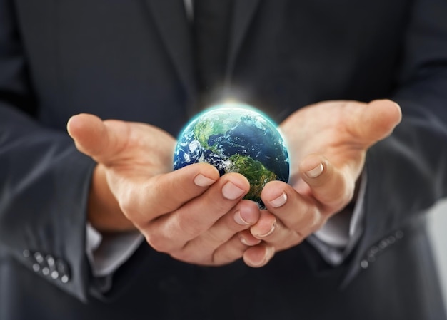 Ethical business Cropped image of a businessman holding a globe in his cupped hands