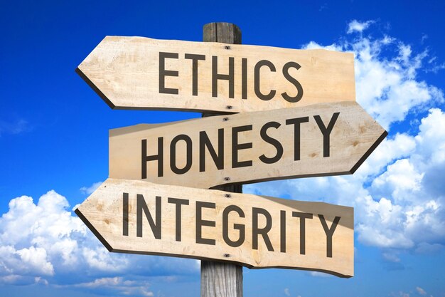 Ethics honesty integrity wooden signpost with three arrows sky with clouds in background