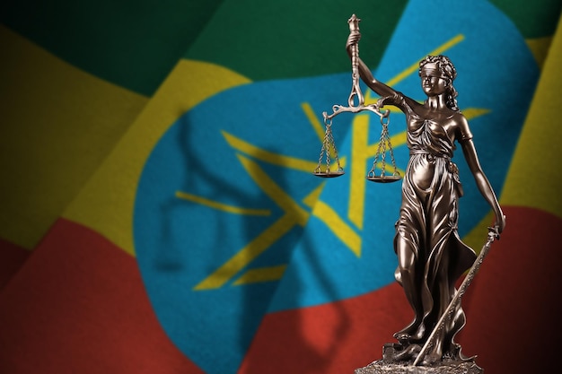 Ethiopia flag with statue of lady justice and judicial scales in dark room Concept of judgement and punishment