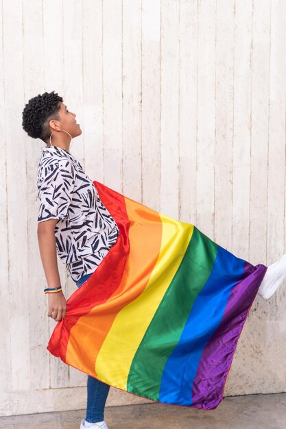 Ethnic woman with multicolored flag representing symbolic LGBTQ stripes