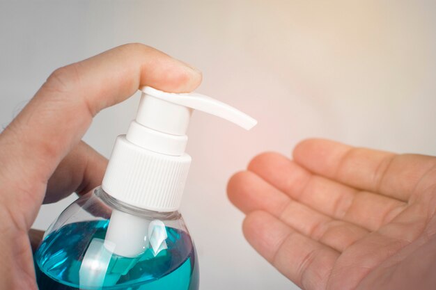 Ethylalcohol gel ontsmettingsmiddel, Mannen houdt fles voor het reinigen van de hand en wordt gebruikt als ontsmettingsmiddel, Covid-19, Corona-virus.