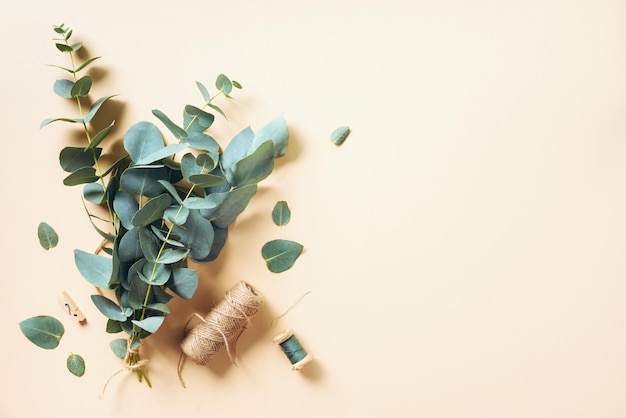 Eucalyptus bouquet creating with baby blue eucalyptus branches over pastel background Florist work concept Top view Flat lay