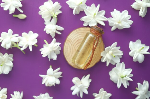 Oli essenziali di eucalipto in una bottiglia di vetro e fiori su viola