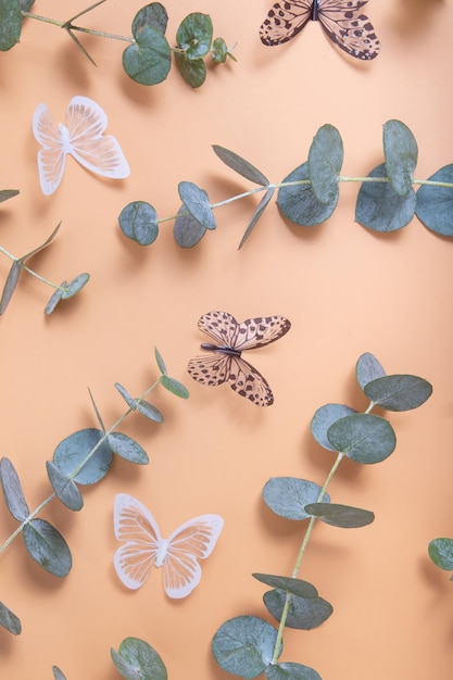 Photo eucalyptus leaves on an orange background bluegreen leaves on branches butterflies for abstract natural spring background