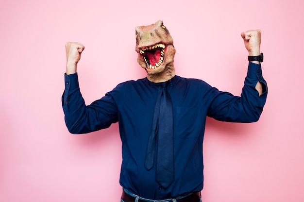 Фото Эйфорический человек с головой динозавра с поднятыми кулаками