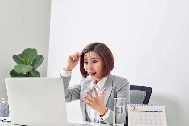 Euphoric and surprised winner online watching a laptop at office, Beautiful young woman glad and surprised after open email on laptop.