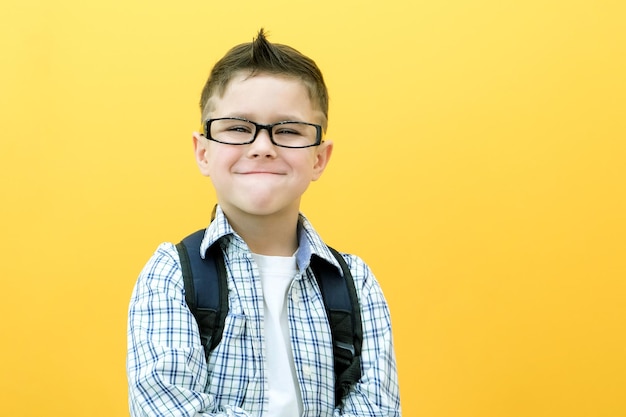 Eureka handsome little boy in glasses is surprised inspired i have an idea raise your index finger up copy space isolated on yellow background