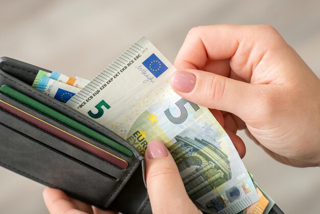 Euro banknote in wallet in hands of a woman close up