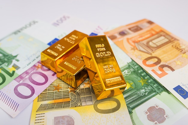 Банкноты евро и золотые слитки крупным планом