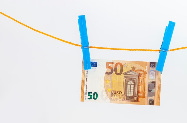 Euro banknotes attached with clothespins to a rope on white isolated background