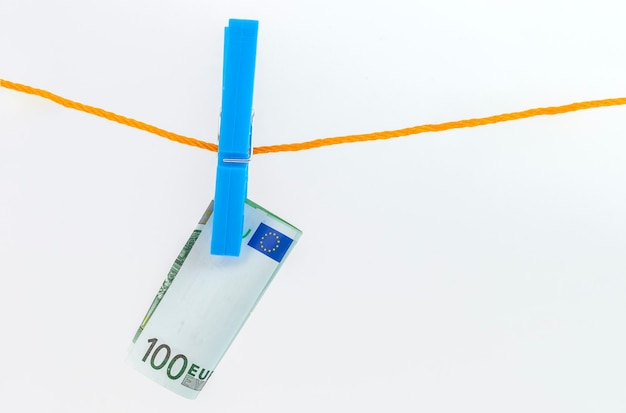 Euro banknotes attached with clothespins to a rope on white isolated background