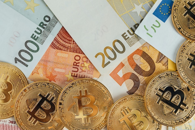 Euro Banknotes and Bitcoin cryptocurrency investing concept. Euro Money and Crypto currency golden bitcoin coin.