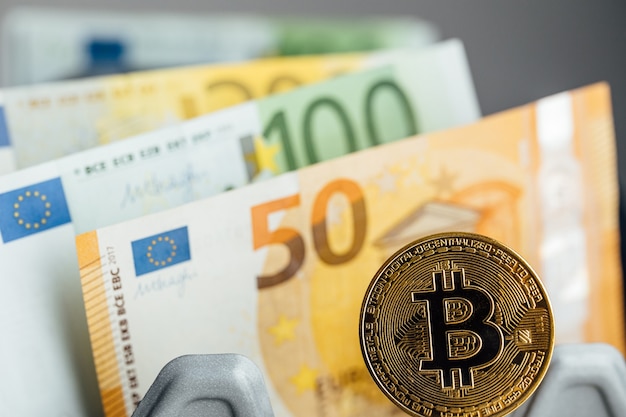 euro banknotes and bitcoin cryptocurrency investing concept. euro money and crypto currency golden bitcoin coin.