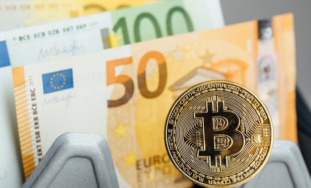 Euro Banknotes and Bitcoin cryptocurrency investing concept. Euro Money and Crypto currency golden bitcoin coin.