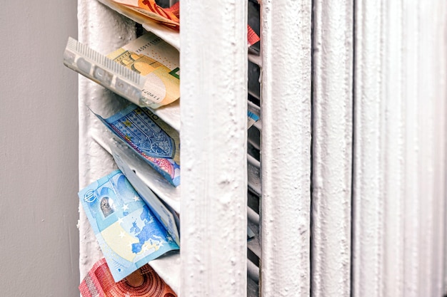 Photo euro banknotes in a central heating radiator the concept of expensive heating costs closeup