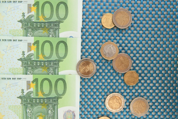 Euro banknotes and euro cents on blue background