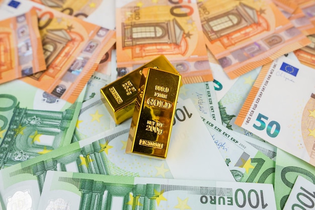 Euro banknotes and gold bars Gold bars on money