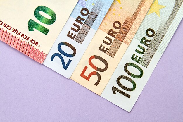 Euro banknotes on purple background